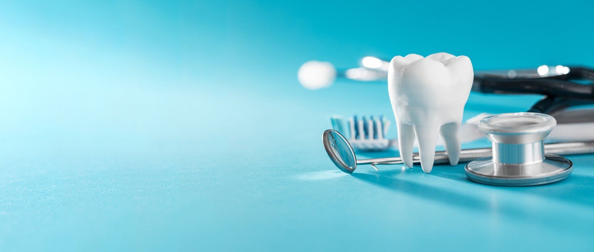 Dente, spazzolino, specchietto e stetoscopio su fondo azzurro