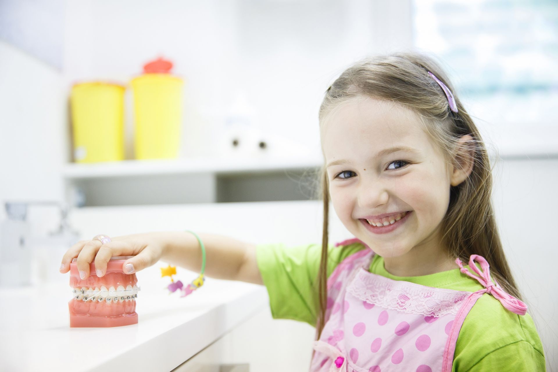 Bambina sorridente con un modello delle arcate dentali